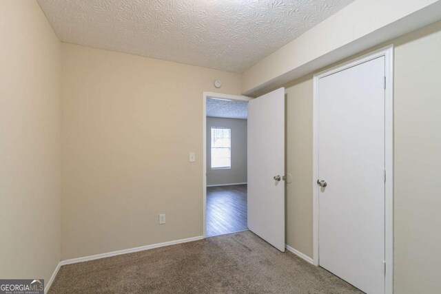 unfurnished bedroom with carpet and a textured ceiling