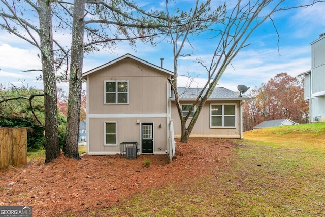 rear view of house with a yard and cooling unit