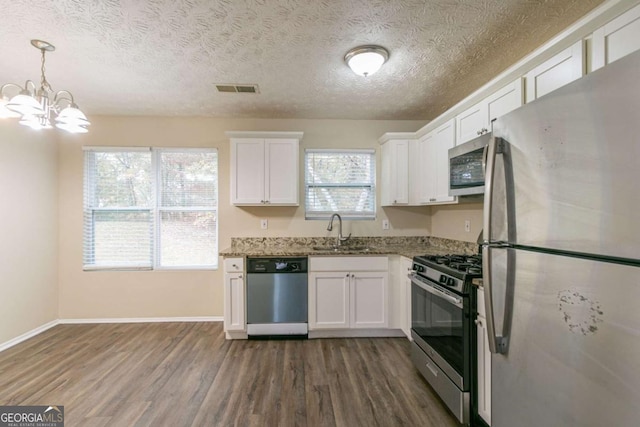 kitchen featuring white cabinetry, light stone countertops, sink, stainless steel appliances, and a textured ceiling