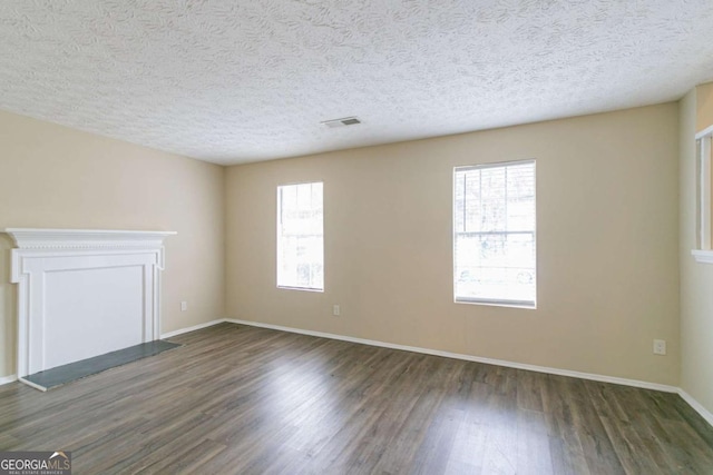 unfurnished room featuring dark hardwood / wood-style floors and a textured ceiling