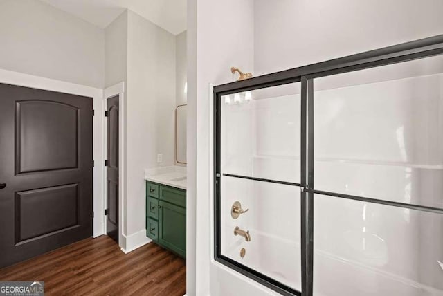 bathroom featuring wood-type flooring, vanity, and shower / bath combination with glass door