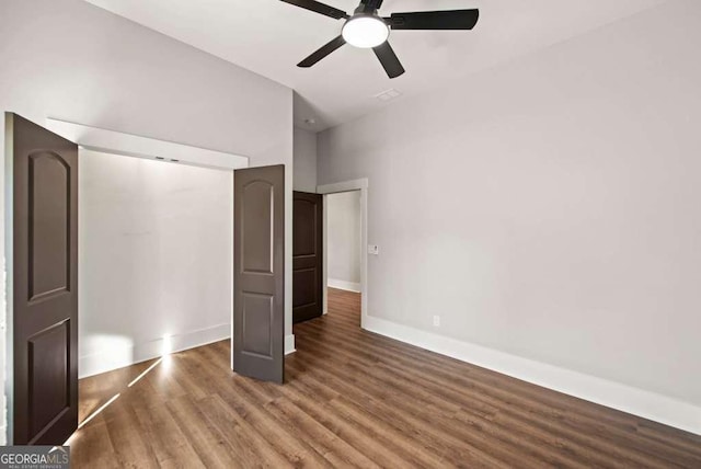 unfurnished bedroom featuring dark wood-type flooring and ceiling fan