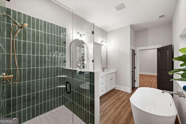 bathroom with vanity, hardwood / wood-style floors, and plus walk in shower