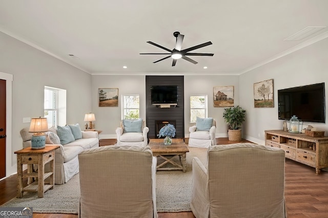 living room featuring hardwood / wood-style floors, crown molding, a large fireplace, and ceiling fan