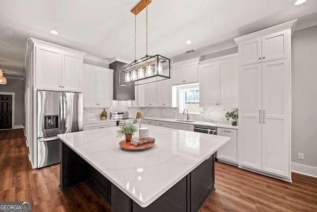 kitchen with stainless steel appliances, white cabinetry, a center island, and pendant lighting