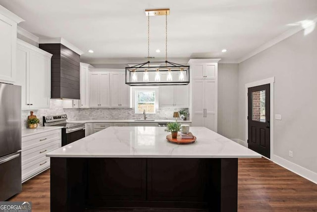 kitchen featuring a kitchen island, decorative light fixtures, sink, white cabinets, and stainless steel appliances