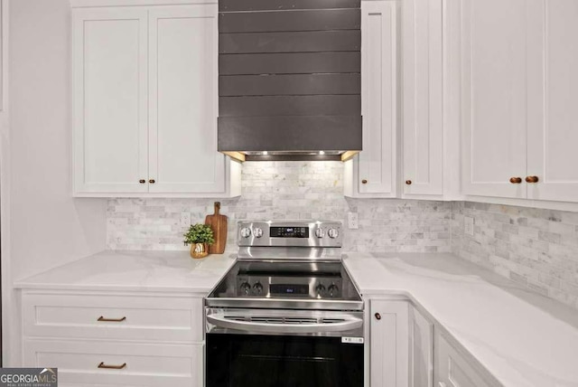 kitchen featuring backsplash, stainless steel range with electric cooktop, white cabinets, and light stone countertops