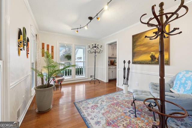 living area featuring hardwood / wood-style floors and crown molding