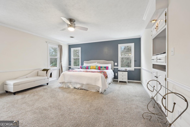 carpeted bedroom with a textured ceiling, ceiling fan, and ornamental molding