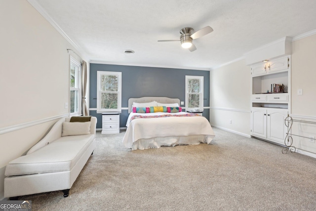 carpeted bedroom with ceiling fan and crown molding