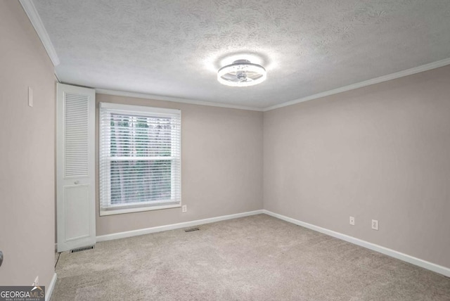 carpeted empty room with ornamental molding and a textured ceiling