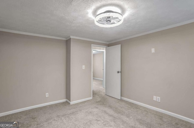 carpeted empty room with a textured ceiling and crown molding