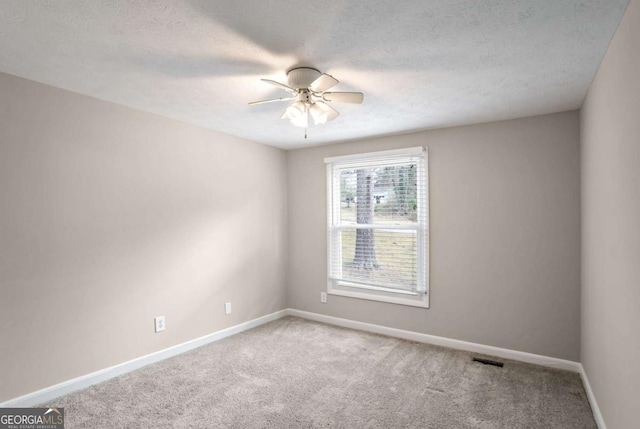 carpeted empty room featuring a textured ceiling and ceiling fan