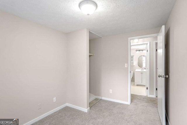 unfurnished bedroom with light carpet and a textured ceiling