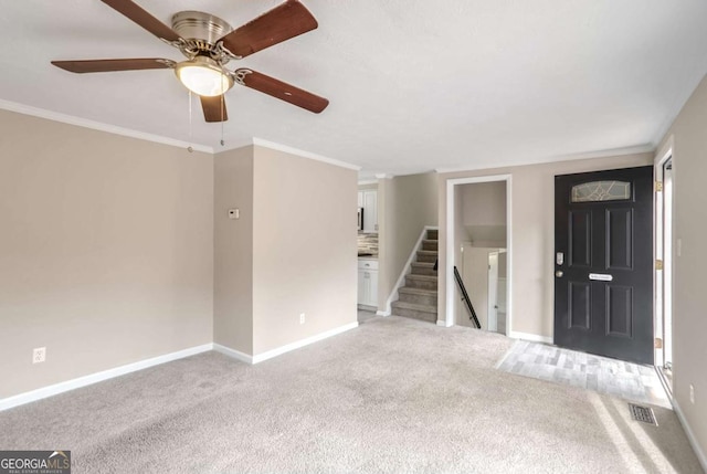 unfurnished living room with ceiling fan, crown molding, and carpet