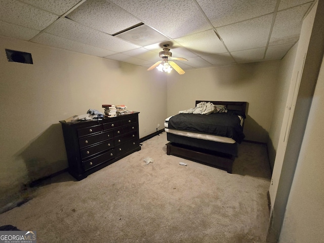 carpeted bedroom with a paneled ceiling and ceiling fan