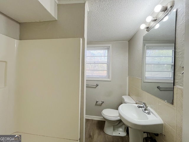 bathroom featuring toilet, sink, a textured ceiling, and hardwood / wood-style floors