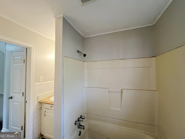 bathroom with tile walls, shower / bathtub combination, and vanity