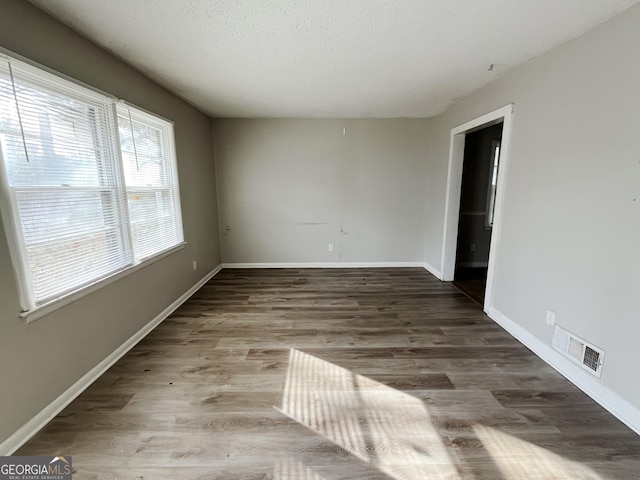 spare room with a textured ceiling and hardwood / wood-style flooring