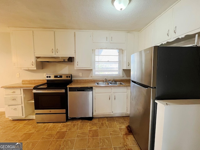 kitchen with appliances with stainless steel finishes, white cabinetry, a textured ceiling, and sink