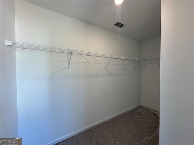 spacious closet featuring dark carpet