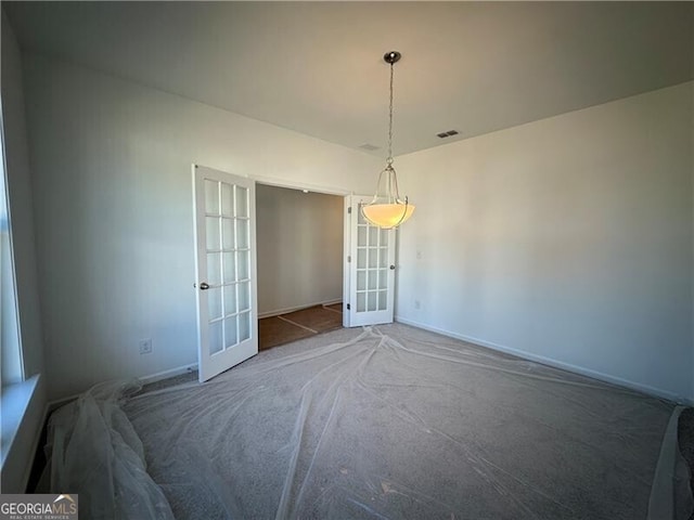 carpeted spare room with french doors