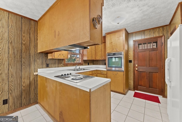 kitchen featuring wooden walls, ornamental molding, kitchen peninsula, a textured ceiling, and white appliances