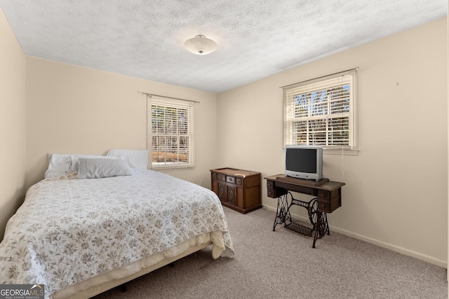 bedroom with light carpet, multiple windows, and a textured ceiling