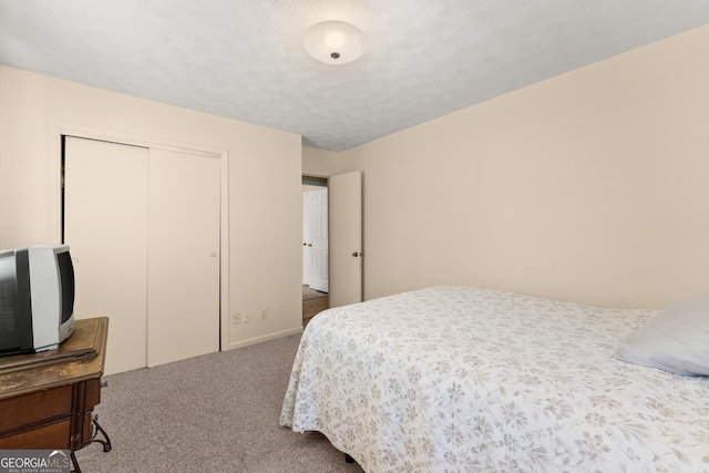 bedroom featuring carpet flooring, a textured ceiling, and a closet