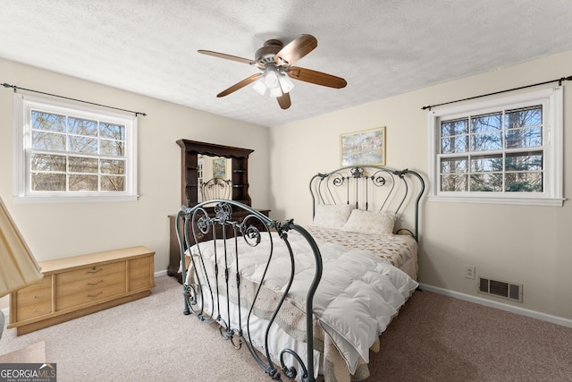 bedroom featuring ceiling fan, carpet floors, and a textured ceiling