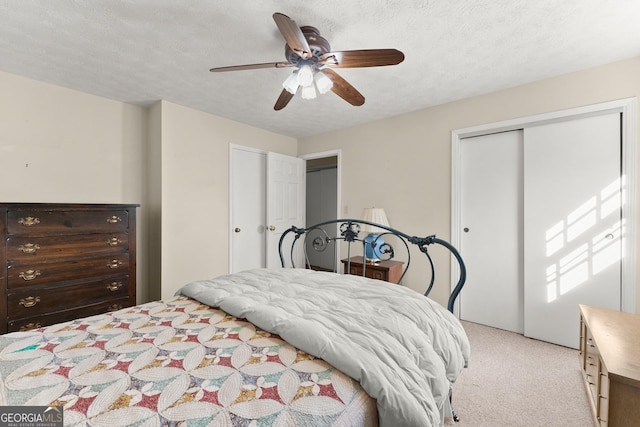 bedroom featuring light carpet, a textured ceiling, ceiling fan, and a closet