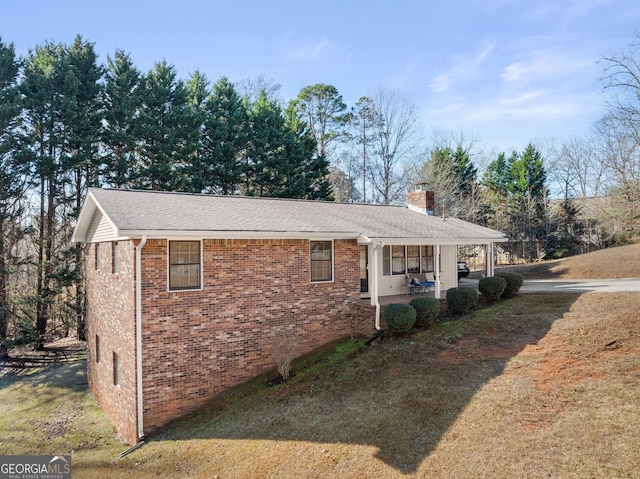 view of home's exterior featuring covered porch and a lawn