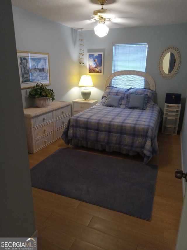 bedroom with hardwood / wood-style floors and ceiling fan