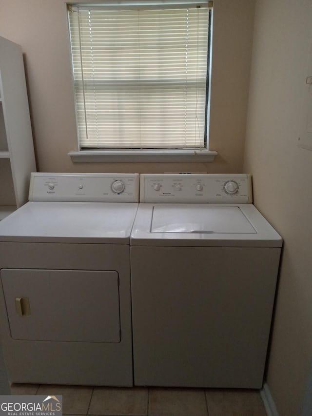 clothes washing area with washing machine and dryer and light tile patterned floors