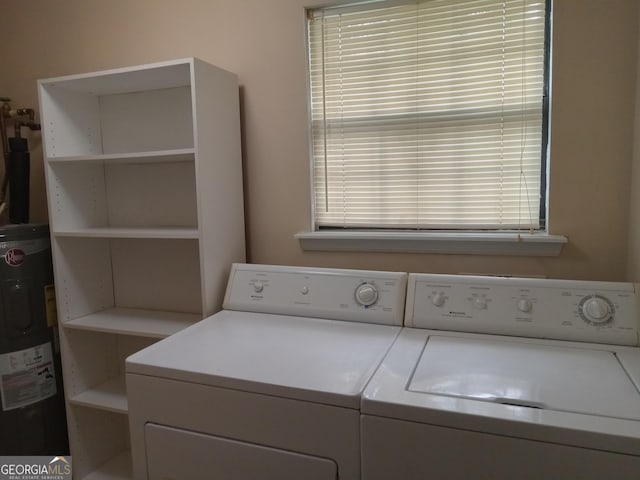 washroom with a wealth of natural light, washing machine and clothes dryer, and electric water heater