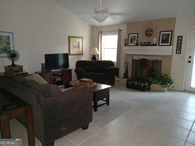 tiled living room featuring vaulted ceiling, a fireplace, and ceiling fan