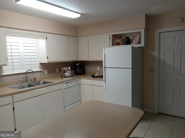 kitchen featuring white appliances, a textured ceiling, light tile patterned floors, white cabinets, and sink