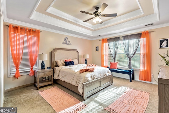 bedroom featuring ornamental molding, light carpet, and a tray ceiling