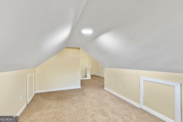 additional living space with light carpet and vaulted ceiling