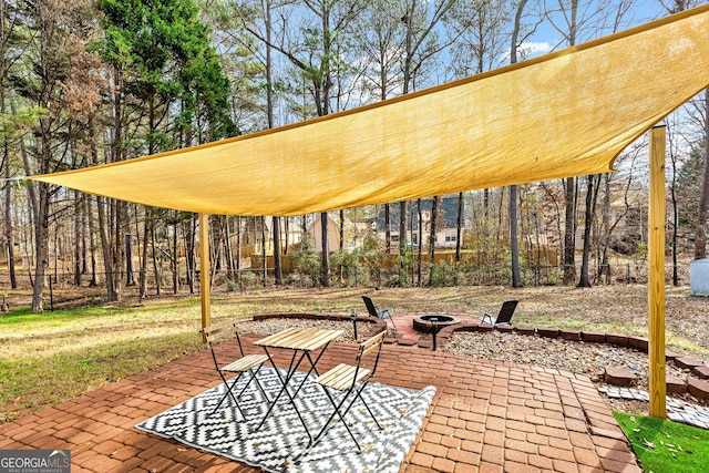 view of property's community with a patio and a fire pit