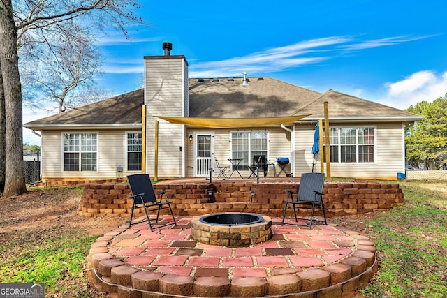 rear view of house with a patio and a fire pit