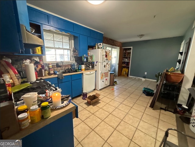 kitchen with light tile patterned flooring, white appliances, blue cabinets, and sink