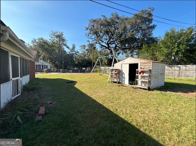 view of yard with a storage unit and a playground