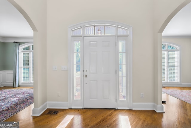 foyer entrance with hardwood / wood-style flooring and ornamental molding