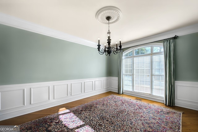 unfurnished room with crown molding and a chandelier