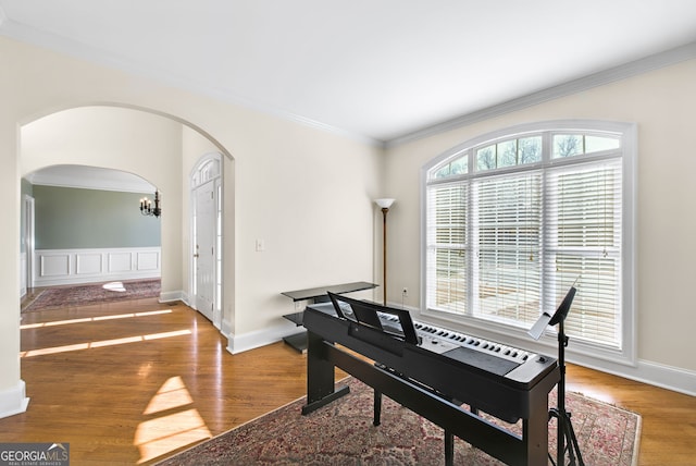 misc room featuring hardwood / wood-style flooring, ornamental molding, and a chandelier