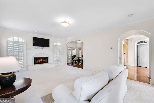 living room featuring ornamental molding, light carpet, and a brick fireplace