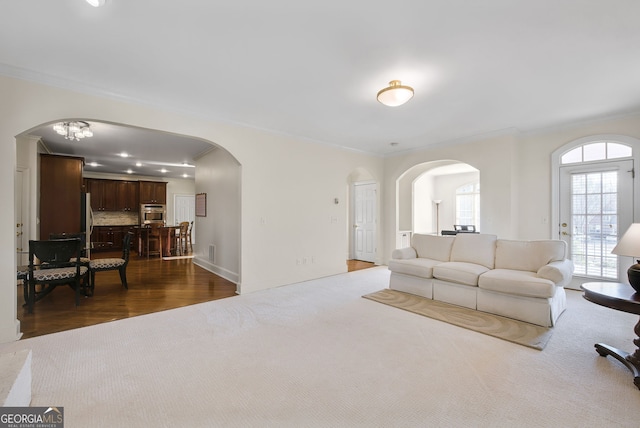 carpeted living room with crown molding