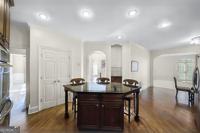 dining room featuring dark hardwood / wood-style flooring and crown molding