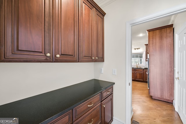 interior space featuring crown molding, sink, and light hardwood / wood-style floors